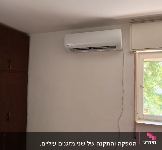 מזגן מותקן על קיר בחדר עם חלון